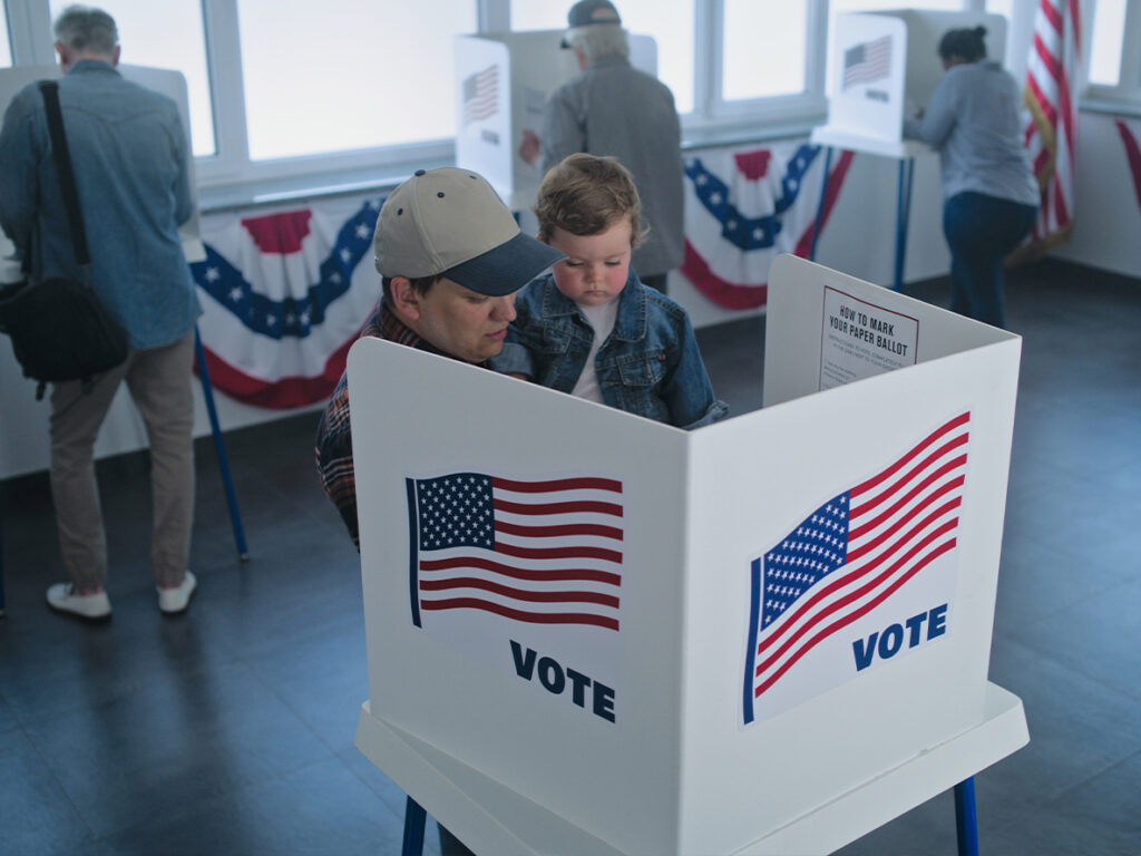 Adult holding small child while voting
