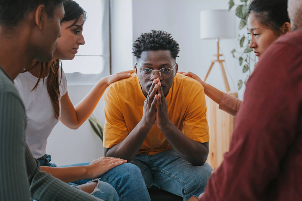 Group supporting young man who is upset