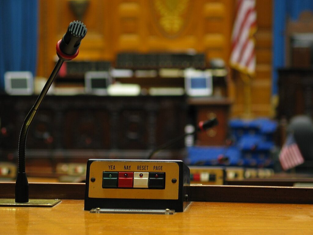 Microphone and voting buttons at chamber desk in a state house.