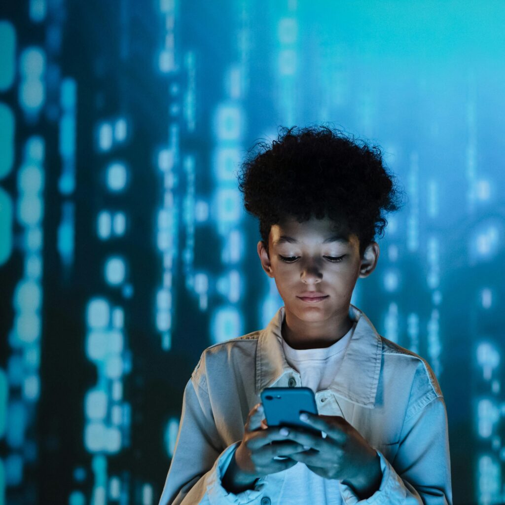 Teen staring into phone among digital graphic background.